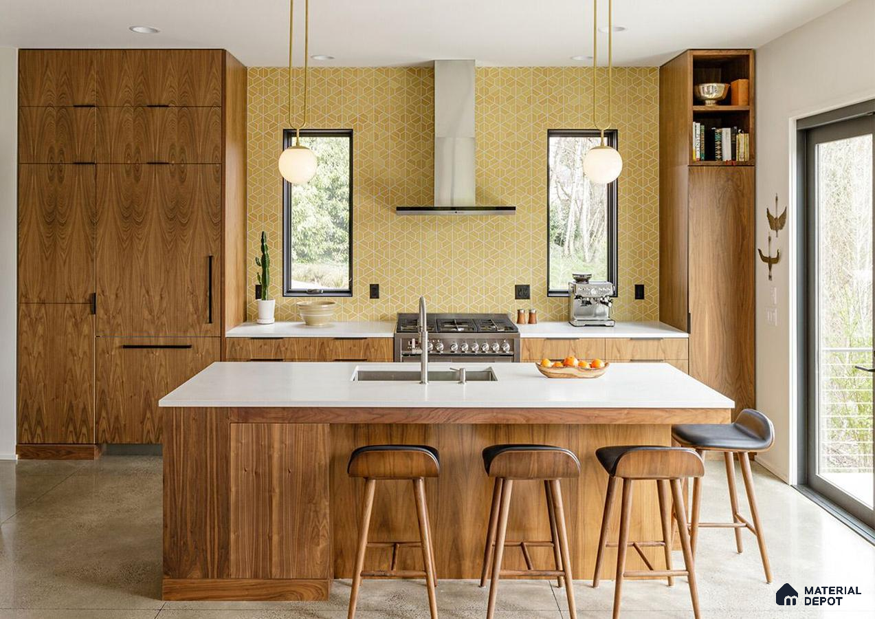 A kitchen with wooden cabinets and white counter tops, along with an island in the middle of the middle of the room with wood flooring and white cabinets and white counter tops is lit by recessed lighting hanging from